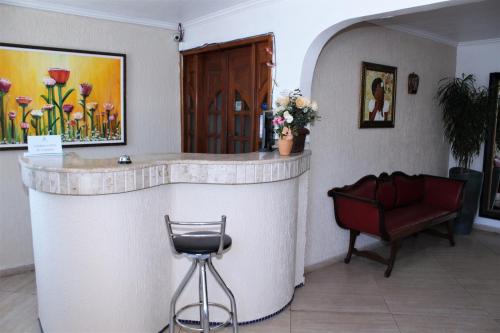 a lobby with a bar with a chair and a couch at Porto Bahia Hotel in Porto Seguro