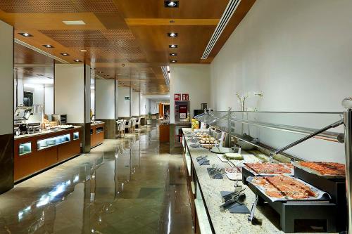 a large kitchen with a buffet line of food at Eurostars Gran Valencia in Valencia