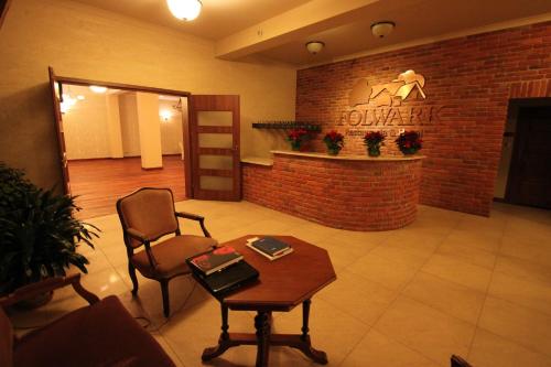 a lobby with a waiting room with a chair and a table at Hotel Folwark in Zgierz