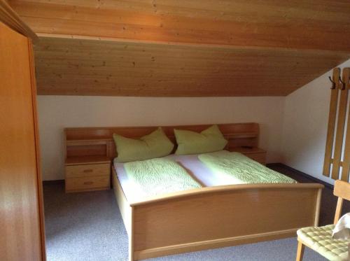 a bedroom with a bed with a wooden bed frame at Haus Gletscherblick in Längenfeld