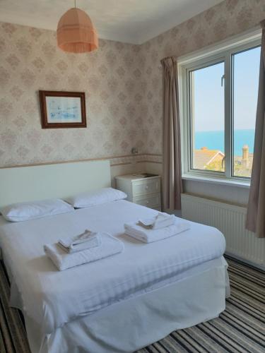 um quarto com uma cama e uma grande janela em The Wight Bay Hotel - Isle of Wight em Sandown