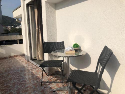 a small table and chairs on a balcony at Villa Merci Budva in Budva