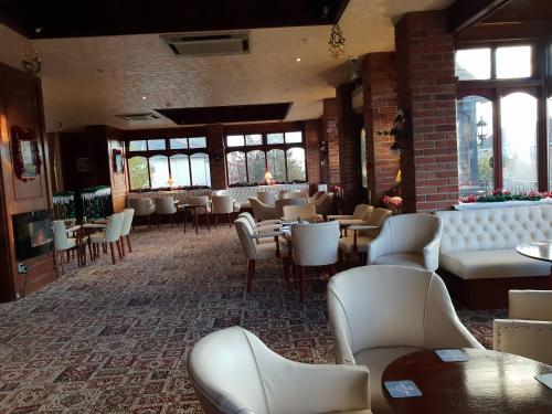 a restaurant with white chairs and tables and windows at The Wight Bay Hotel - Isle of Wight in Sandown