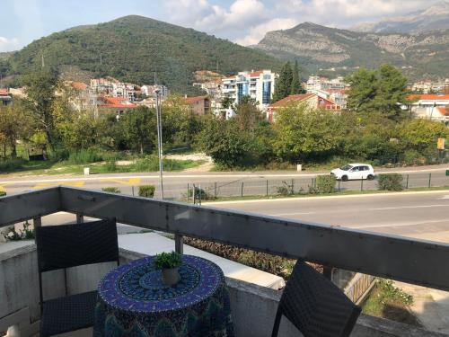 a table on a balcony with a view of a city at Villa Merci Budva in Budva
