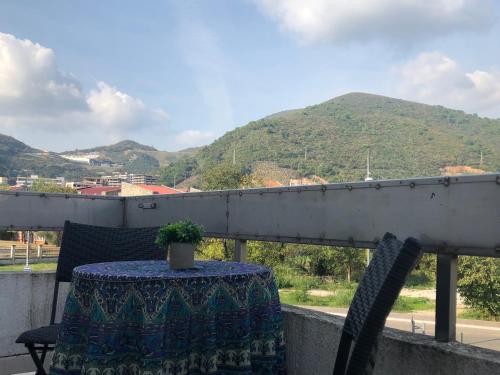 a table and chairs on a balcony with a mountain at Villa Merci Budva in Budva