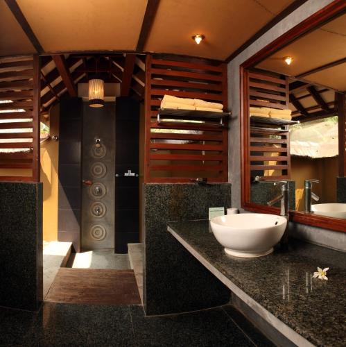 a bathroom with a large sink and a mirror at Poovar Island Resort in Pūvār