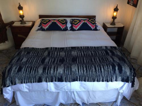 a bedroom with a black and white bed with two lamps at Casa Cuento in Concón