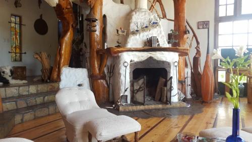 a living room with a fireplace and two chairs at Casa Cuento in Concón