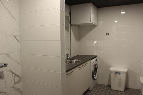 małą białą kuchnię ze zlewem i pralką w obiekcie Majoituspalvelu Nurmi Apartment Oksapolku 2 A Deluxe Huoneisto 60m3 w mieście Raahe