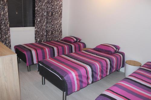 grupa trzech łóżek w pokoju w obiekcie Majoituspalvelu Nurmi Apartment Oksapolku 2 A Deluxe Huoneisto 60m3 w mieście Raahe