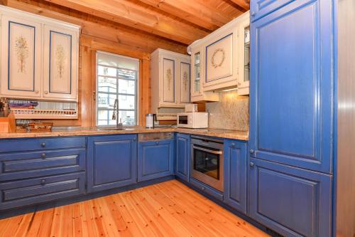 a blue kitchen with wooden walls and wooden floors at Villa Erika in The Heart of Nida in Nida