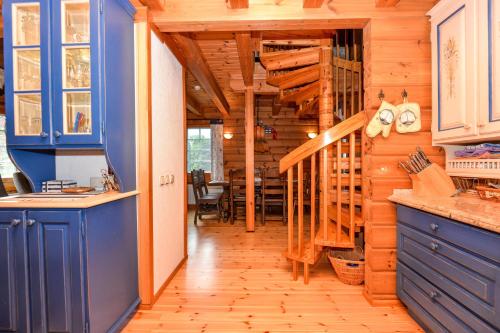 a kitchen with blue cabinets and a wooden wall at Villa Erika in The Heart of Nida in Nida