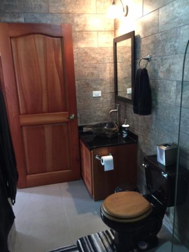 a bathroom with a toilet and a sink and a mirror at Villas Lambeau Ocean View 1 in Uvita