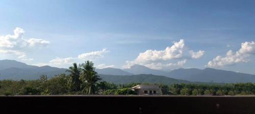 a view of a house with mountains in the background at แสนดีเพลส เกสเฮ้าท์ จอมทอง in Chom Thong