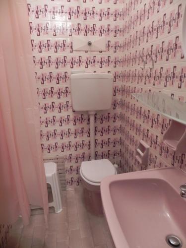 a bathroom with a toilet and a sink and a tub at Hotel Antonella in Caorle