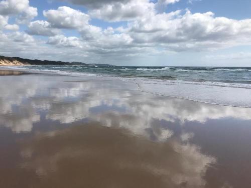 a reflection of the clouds in the water on the beach at Sodwana Bay Lodge House 34 in Sodwana Bay