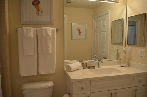a bathroom with a sink and a toilet and a mirror at Fort Myers Luxury Vacation Condo in Fort Myers