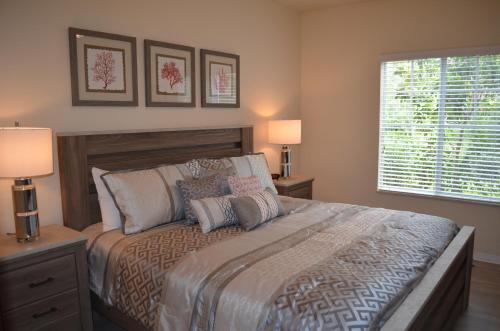 a bedroom with a bed with two lamps and a window at Fort Myers Luxury Vacation Condo in Fort Myers