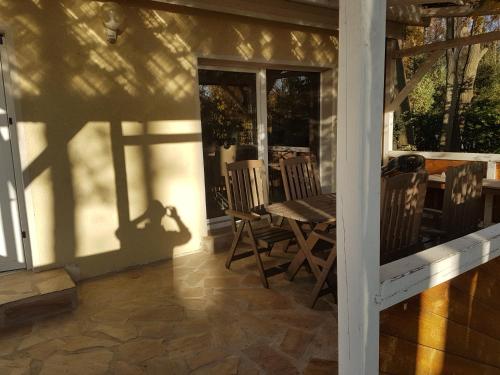 a porch with a table and chairs on a house at Gemutlicher Ferienbungalow am Felsensee bei Pretzien in Pretzien