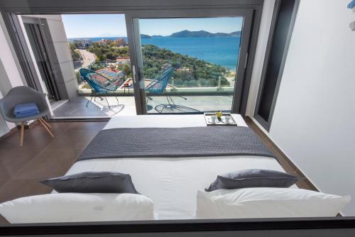 een slaapkamer met een bed en uitzicht op de oceaan bij Villa Evian in PalaiónTsiflíkion