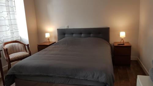 a bedroom with a bed and two lamps on tables at Au Pigeon Blanc in Andouillé