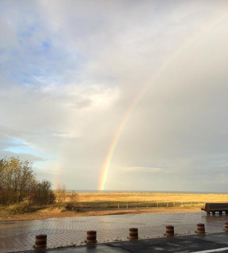 a rainbow in the sky with a bench at Residentie Mariposa in Knokke-Heist