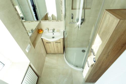 a small bathroom with a sink and a shower at Apartment Cracow in Krakow