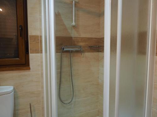 a shower with a hose in a bathroom at Planet Ancares in Candín