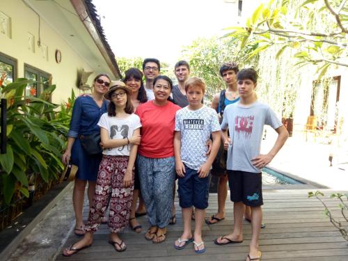 a family posing for a picture on a porch at Pujihouse One in Legian