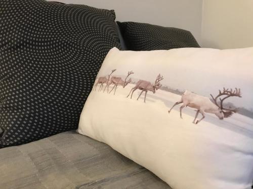 a pillow with a herd of deer on it on a couch at Arctic Sofia Riverstudio in Rovaniemi