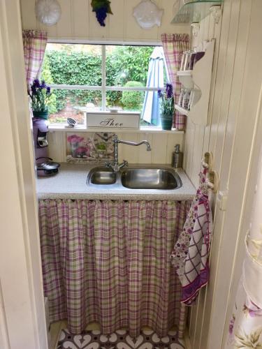 a kitchen with a sink and a window at Logies Het Tuinhuisje in Enschede