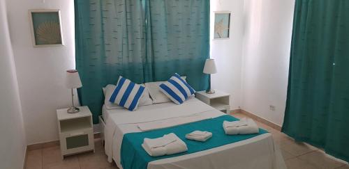a bedroom with a bed with two towels on it at Hotel Agua Dulce in Boca Chica
