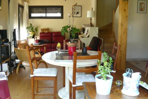 een woonkamer met een tafel en stoelen bij Chambre chez l'habitant in Hauteville-sur-Fier