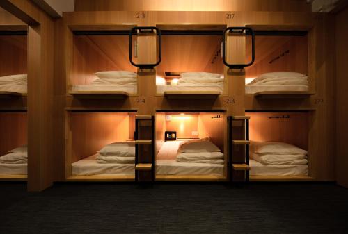 a room with four bunk beds with lights on them at TSUKIMI HOTEL in Kyoto