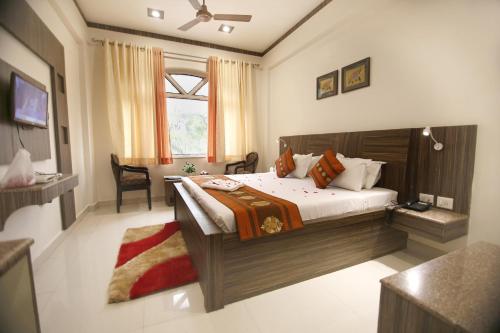a bedroom with a large bed and a desk at Hotel Sheetal Regency,Near Janambhumi in Mathura