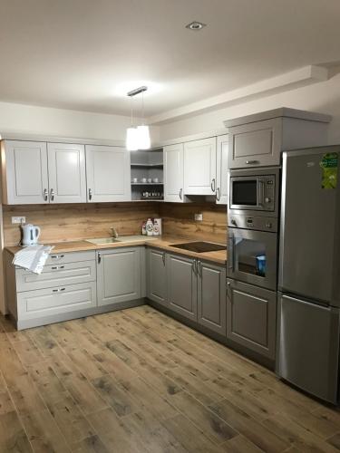 uma cozinha com armários brancos e electrodomésticos de aço inoxidável em Donovaly Panoráma 26 em Donovaly