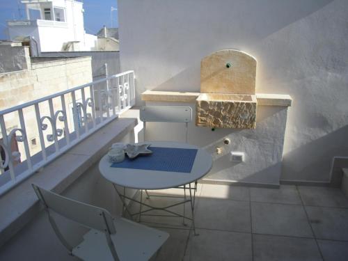 a balcony with a blue table and a stool at Romi' in Polignano a Mare