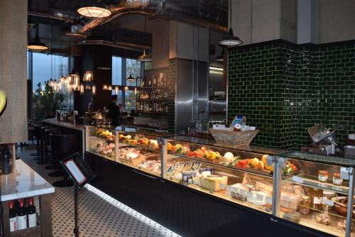 a restaurant with a counter with food on display at London City Island 3 Bedroom Luxury Apartments, Canary Wharf, E14 in London