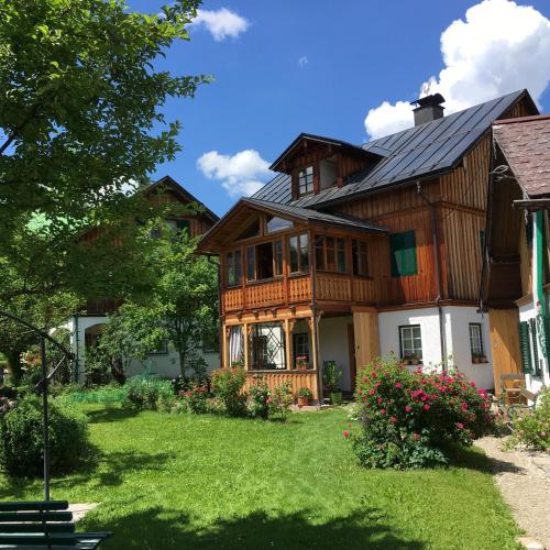 a large wooden house with a green yard at Bergarbeiterhäuser in Altaussee