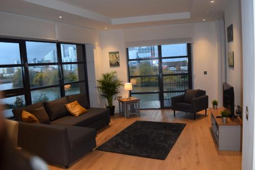 a living room with a couch and a chair at London City Island 3 Bedroom Luxury Apartments, Canary Wharf, E14 in London