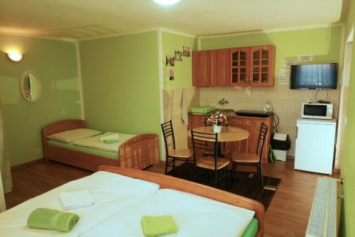 a bedroom with a bed and a kitchen with a table at Apartmán pri zámočku in Bešeňová