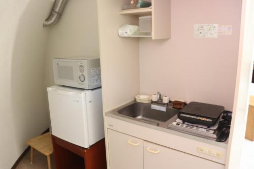 a small kitchen with a sink and a refrigerator at The Hirosawa City Dome House West Building / Vacation STAY 6890 in Chikusei