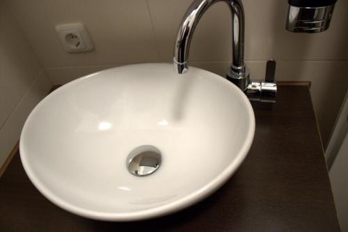 a white sink with a faucet in a bathroom at Porschepension in Wolfsburg