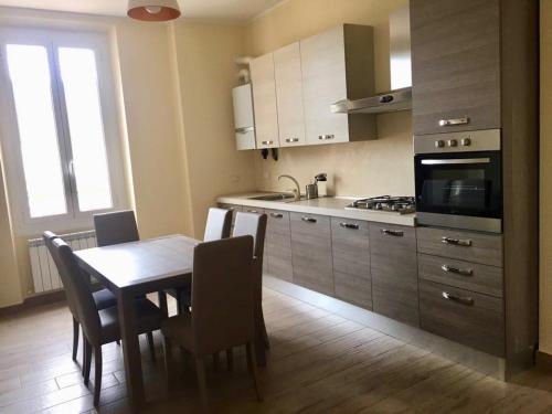 eine Küche mit einem Tisch, Stühlen und einer Mikrowelle in der Unterkunft Appartamento Quasi Perfetto in Sestri Levante