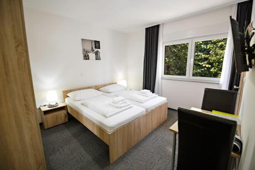 1 Schlafzimmer mit 2 Betten und einem Fenster in der Unterkunft Hostel Mali Pariz in Slavonski Brod