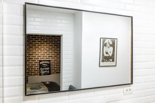 a mirror on a wall with a brick fireplace at Squirrel Apartment in Bucharest