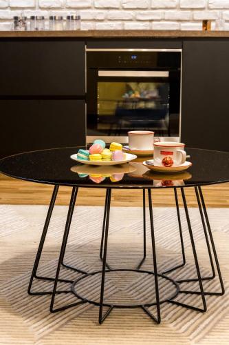 a black table with two plates of food on it at Squirrel Apartment in Bucharest