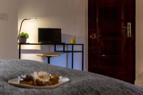 a plate of bread on a table with a computer at Squirrel Apartment in Bucharest
