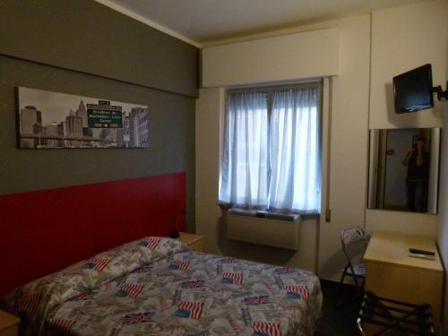 a hotel room with a bed and a window at Hotel La Torre in Cogoleto