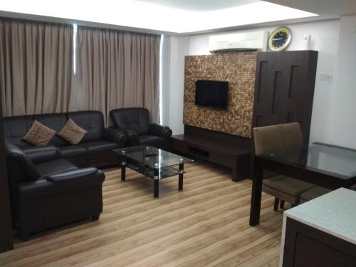 a living room with a couch and a tv at Classy Studio Apartment (KBCP) in Kota Bharu